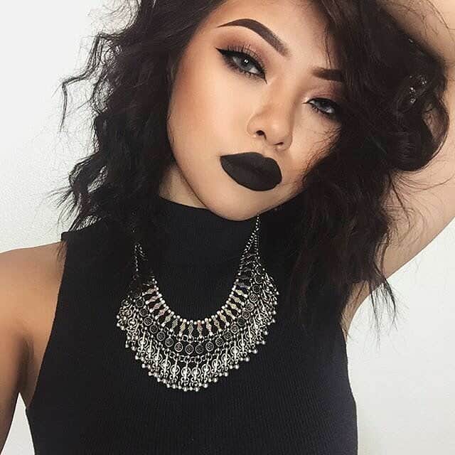 women with black dress and bold makeup